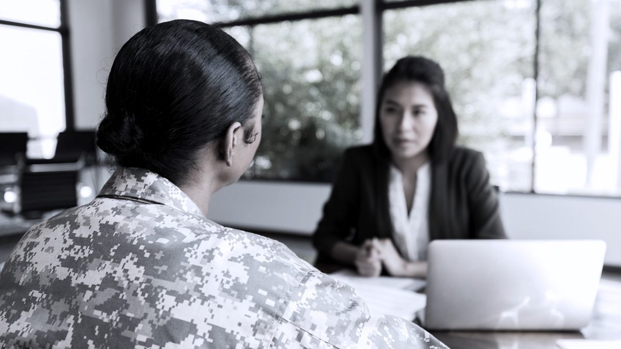 HR leader sitting at a desk interviewing veteran for a job