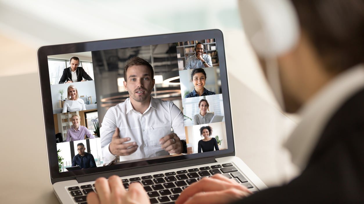 A man is using a laptop with a group of people on it.