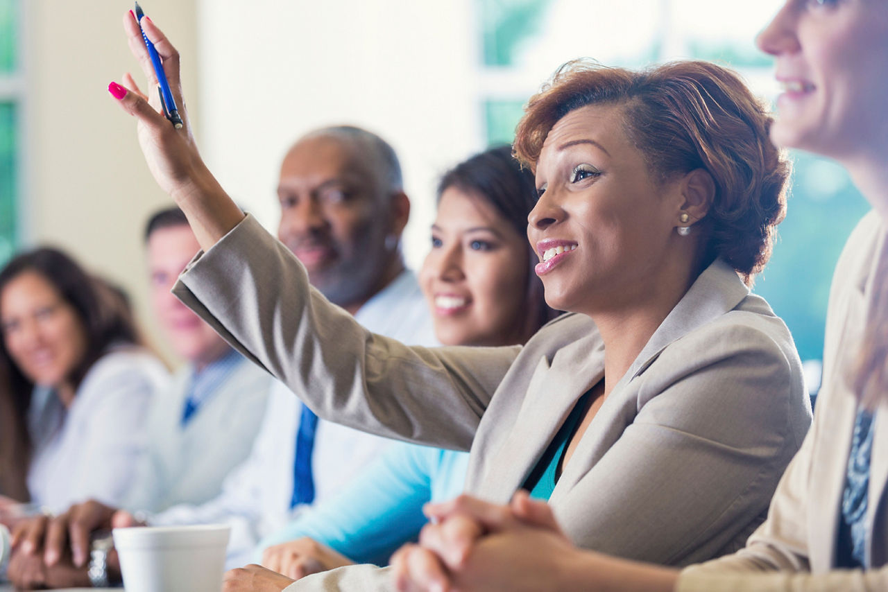 Woman raising hand in group