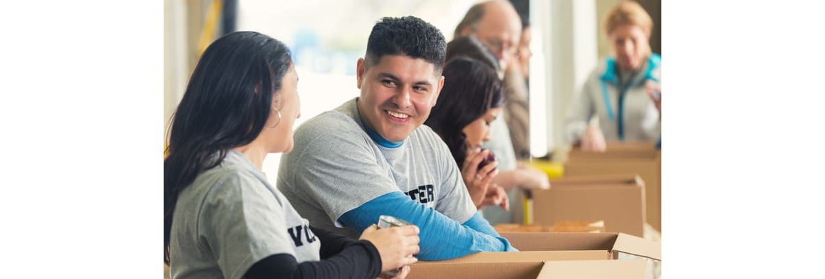 A group of people sitting in boxes in a warehouse.