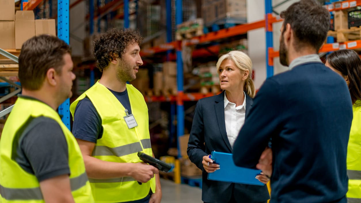 A group of people talking in a warehouse.