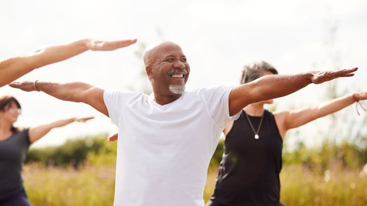 A group of people doing yoga in a field.