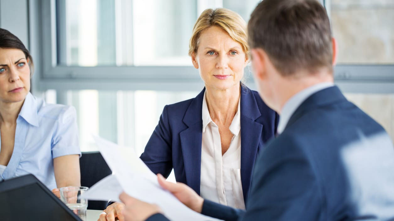 A group of business people talking at a meeting.