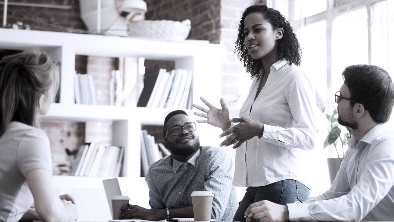 A group of people sitting around a table in an office.