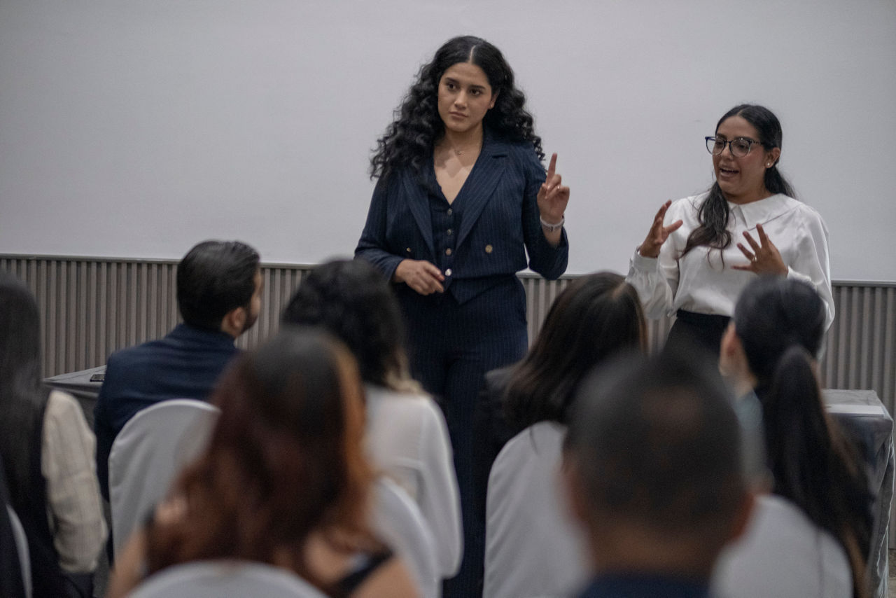 women in professional attire speaking to a group seminar