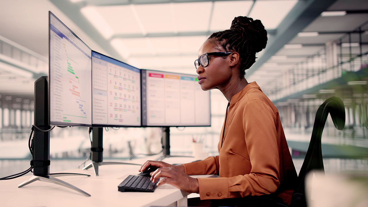An employee at multiple computer screens.