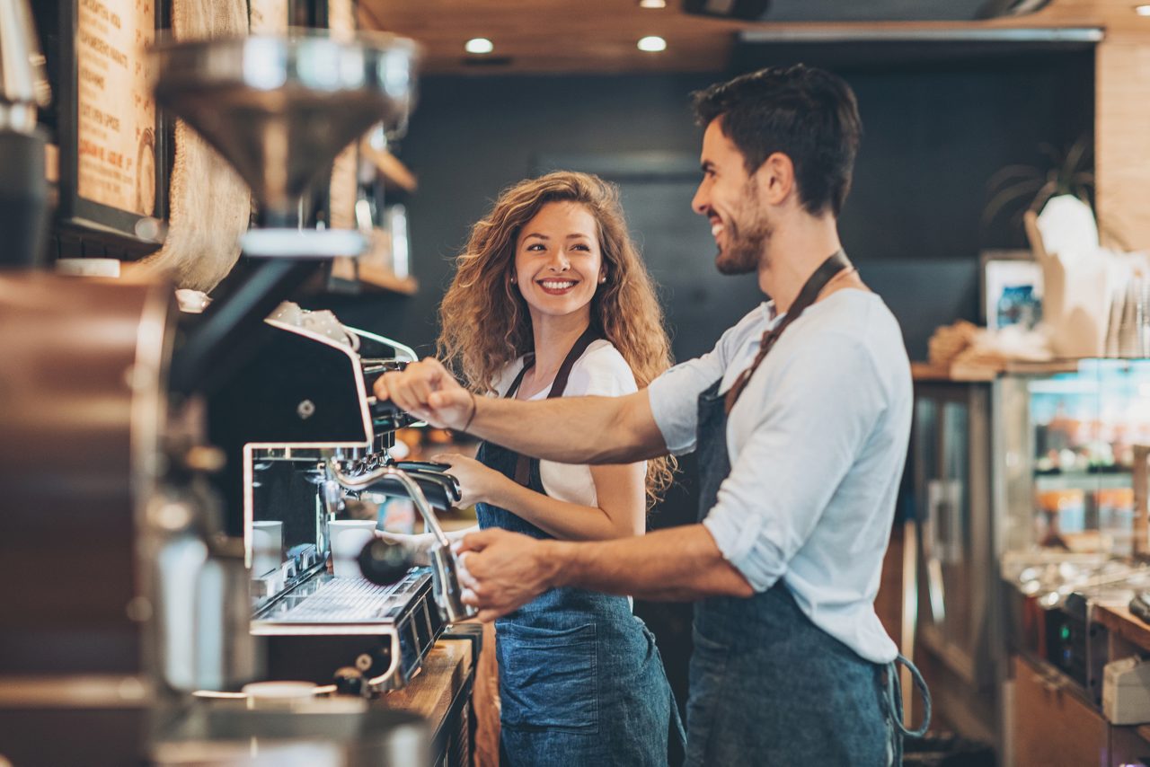 Baristas smile at one another as they work