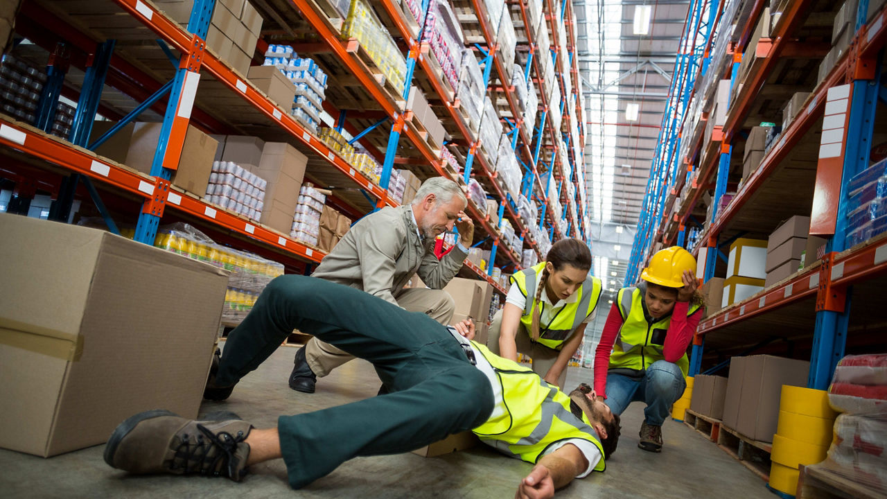 A group of workers laying on the floor in a warehouse.