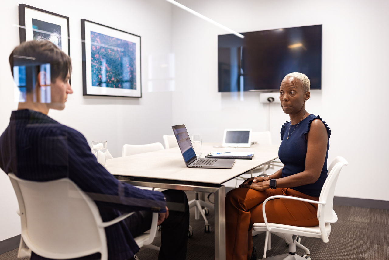 Two women discuss a workplace investigation.