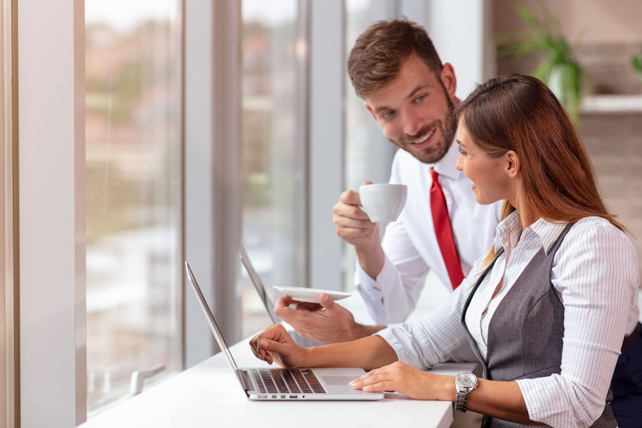 A man and a woman work together in a modern office.