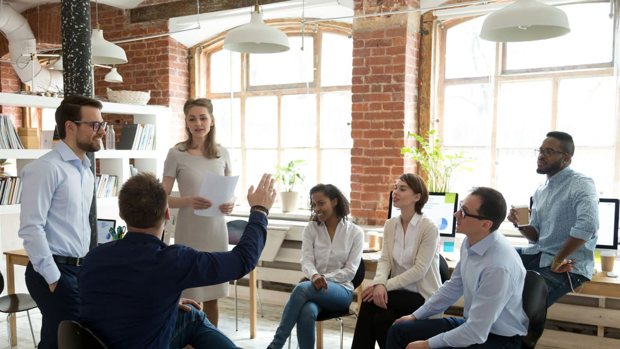 A group of people sitting around a table in an office.