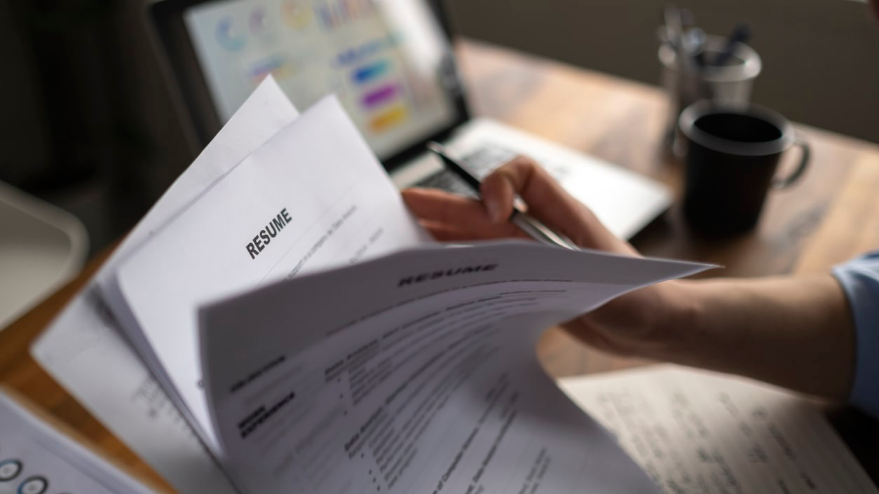 A worker leafing through resumes