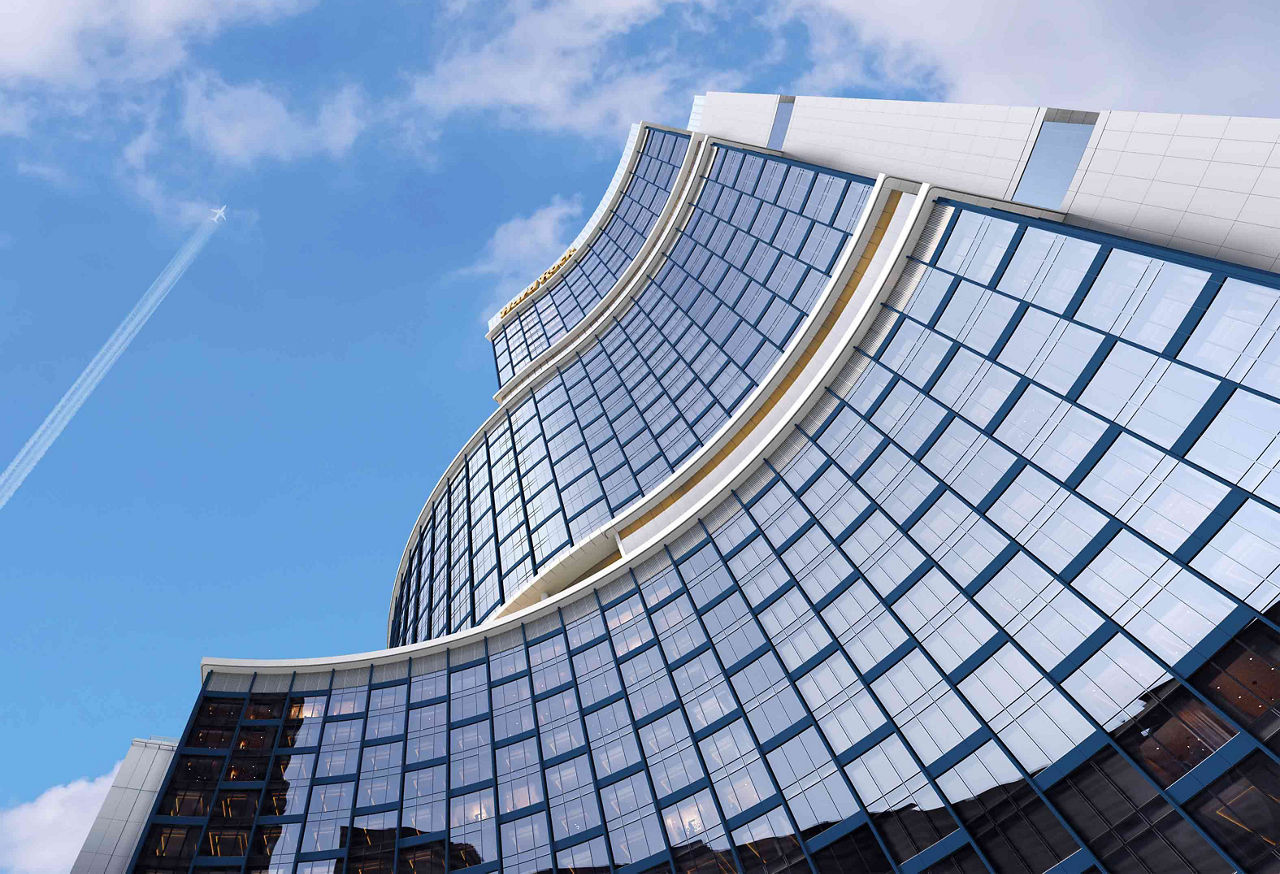 Modern curved glass skyscraper against sky