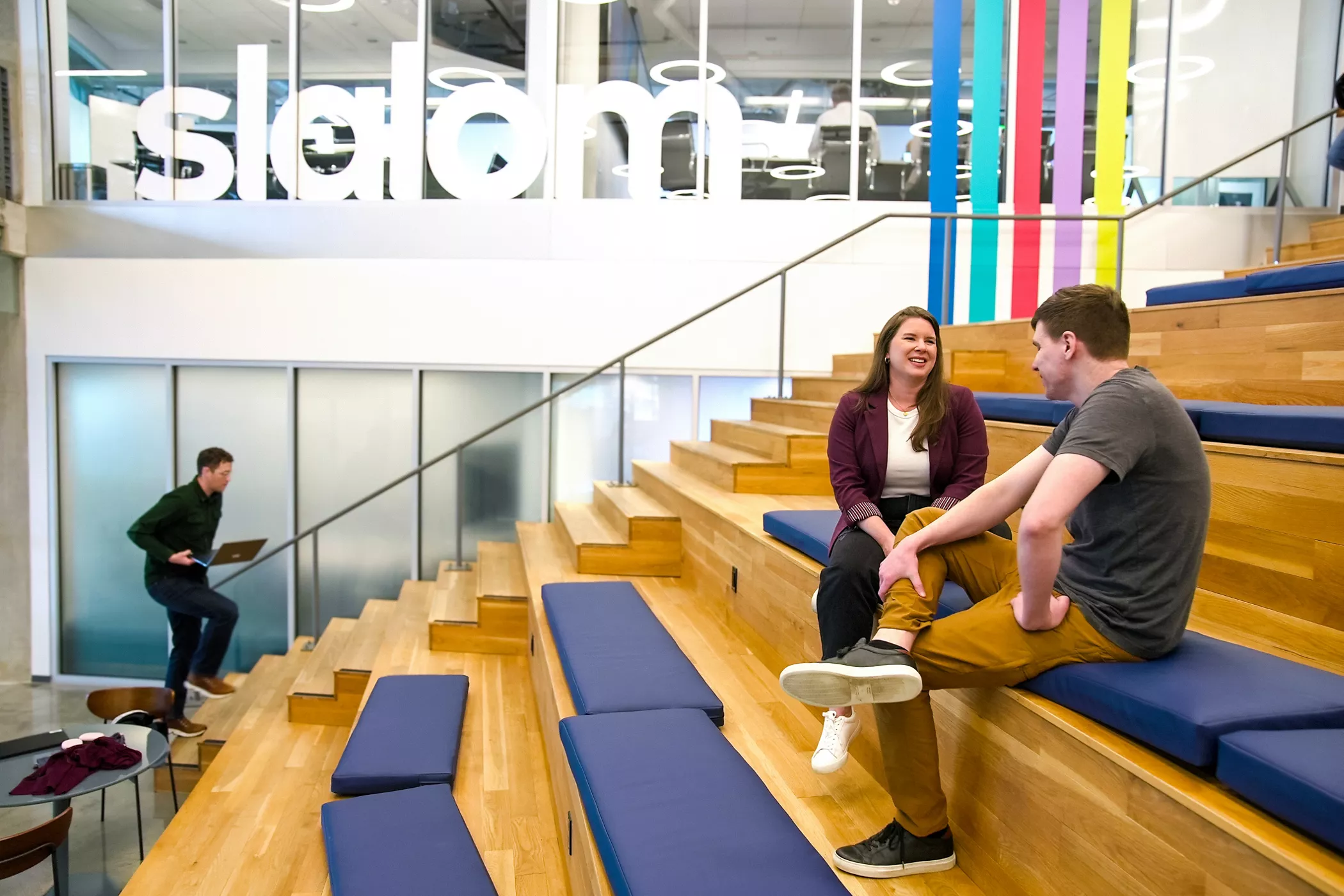Kojiro Iizuka talking to a coworker on a sofa