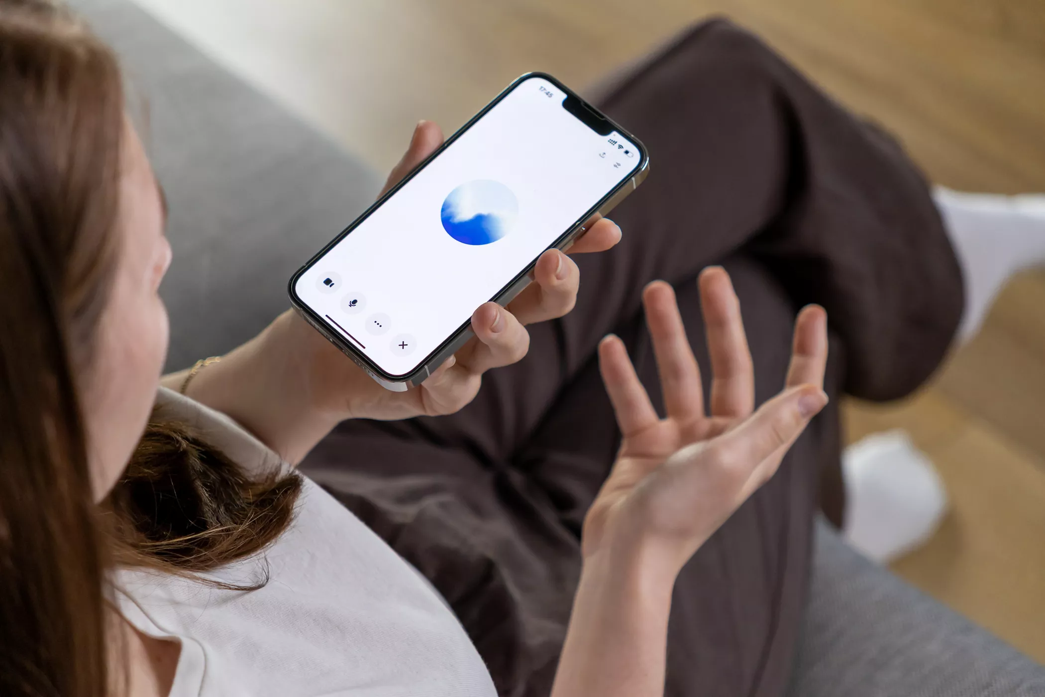 Poznan, Poland – April 14, 2025: A woman interacts with a GPT voice assistant on her smartphone, demonstrating the use of artificial intelligence in daily life