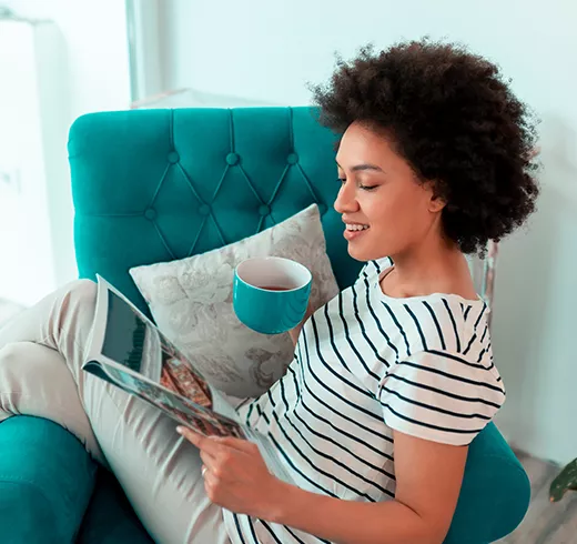 Woman sitting on the couch and reading a magazine