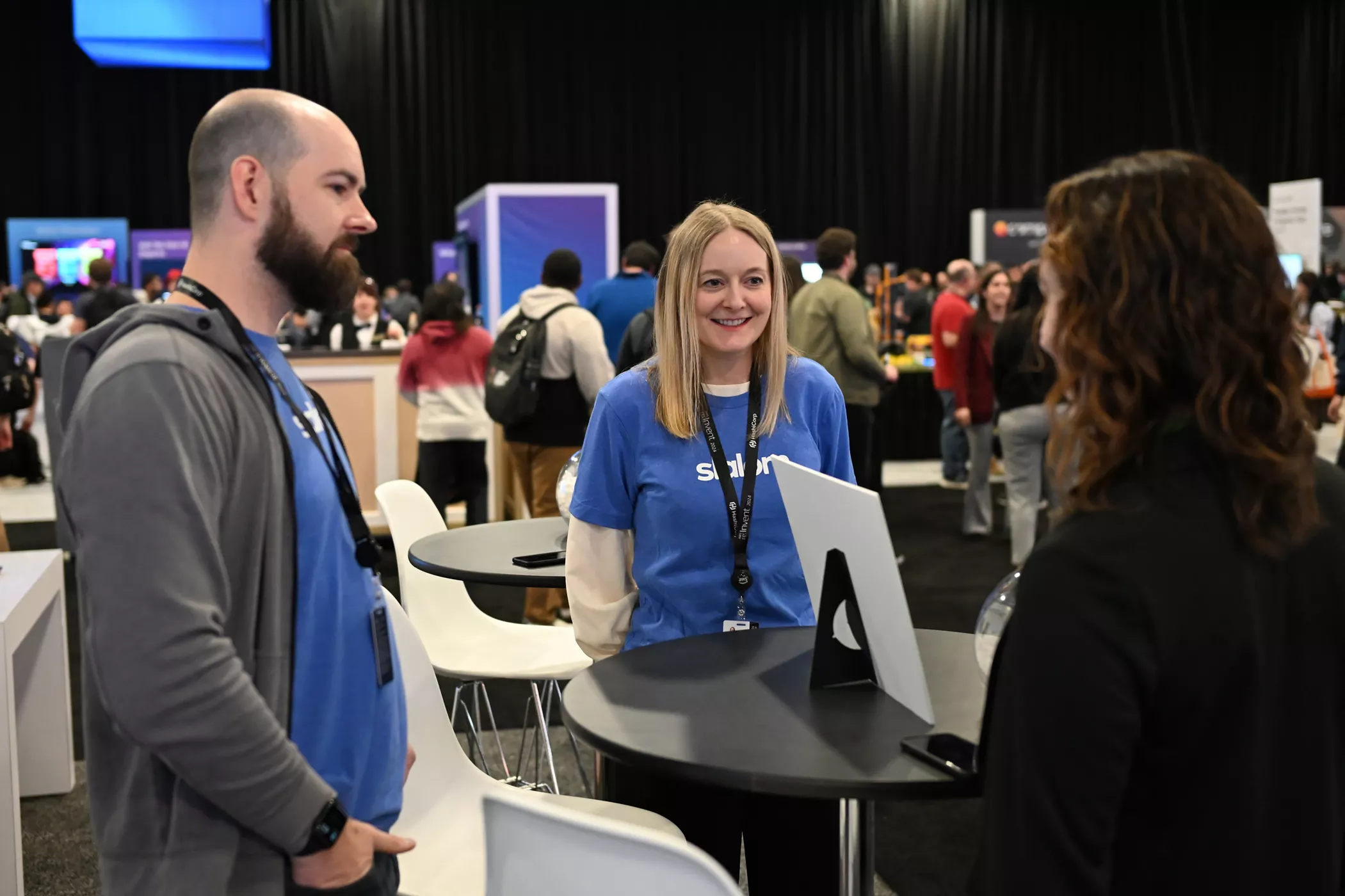 Two women and a man at table having a discussion at the Slalom booth