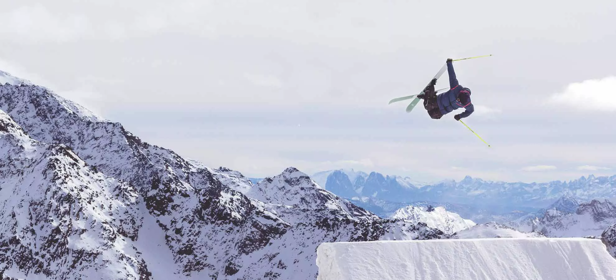 An image of a skier going sking on a snow capped mountains.