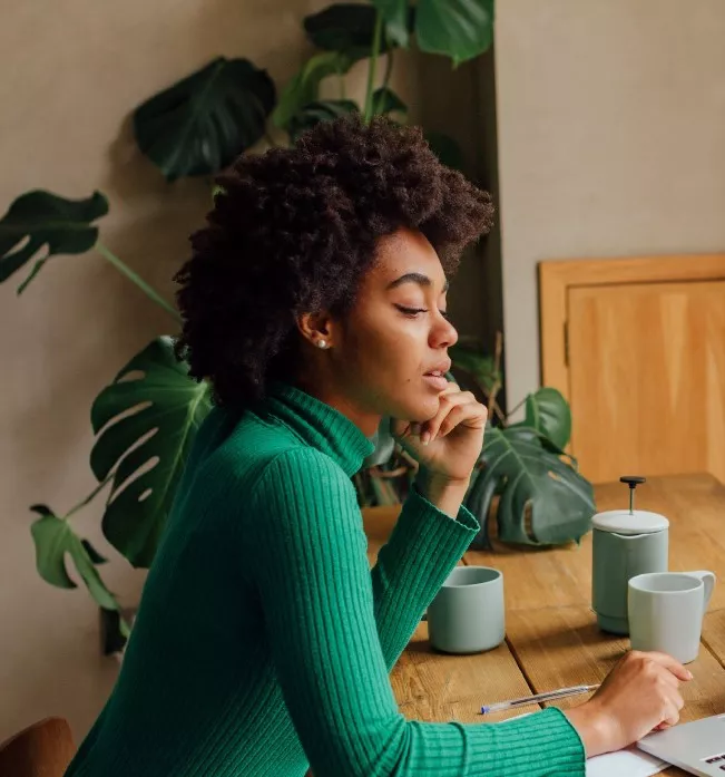 Man and woman working on a laptop at a coffee shop