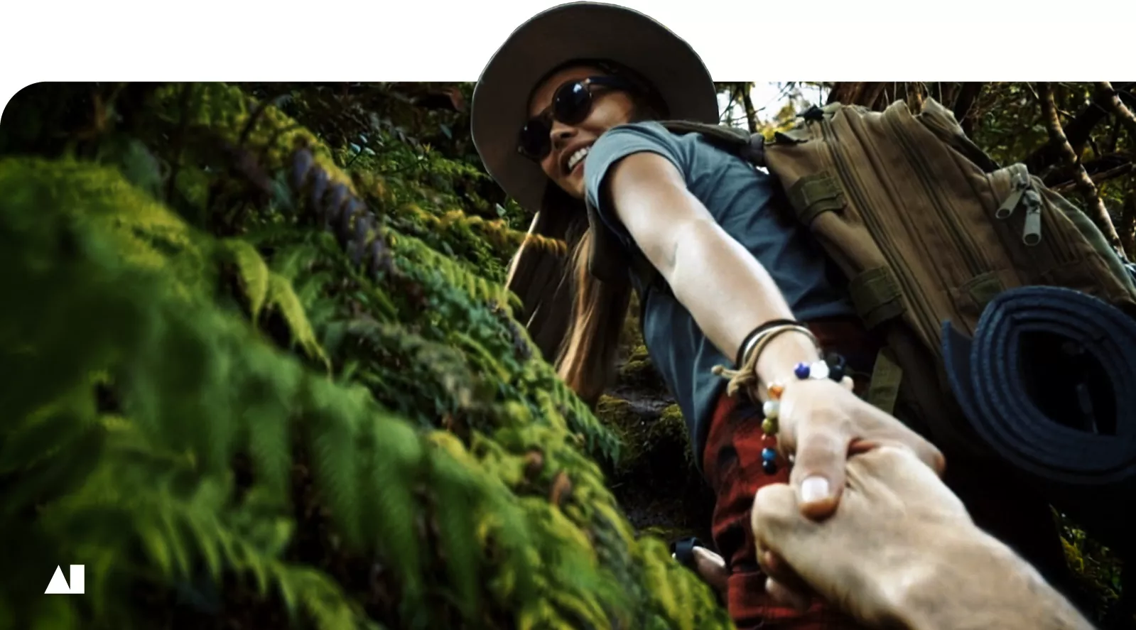 woman walking uphill in jungle holding a male hand and leading the way
