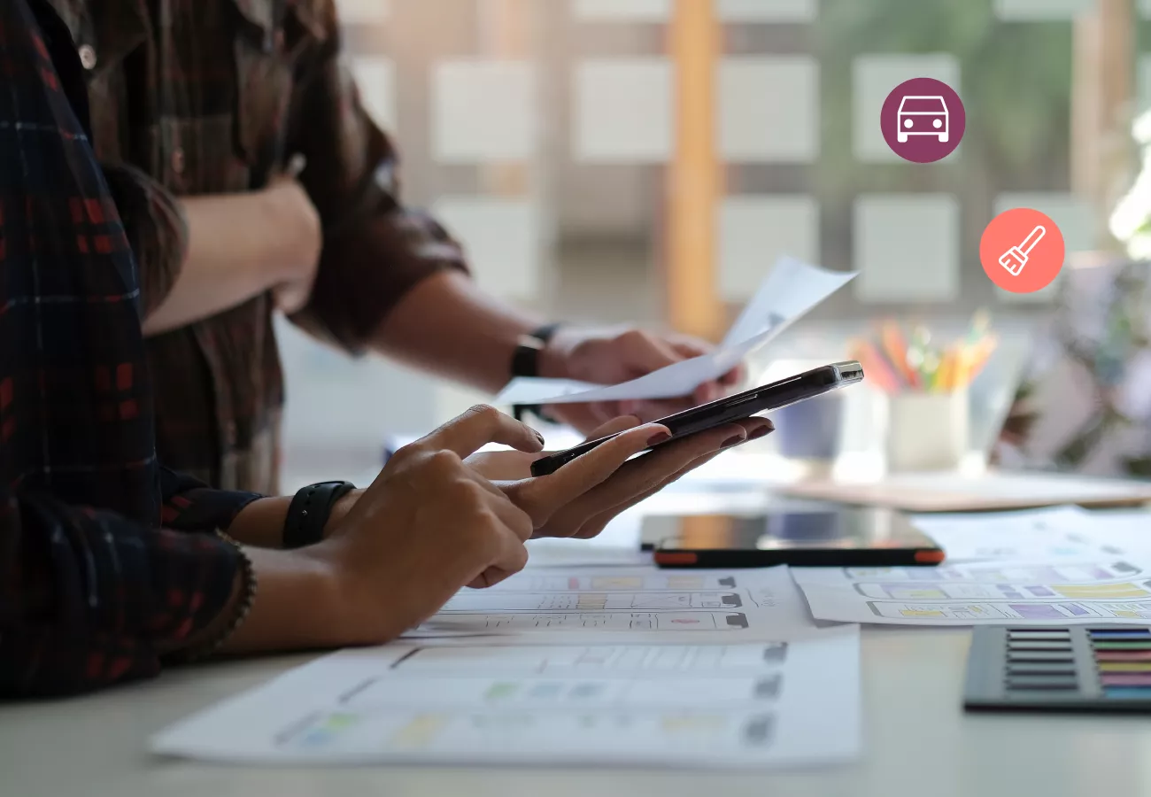two people looking at papers and a phone