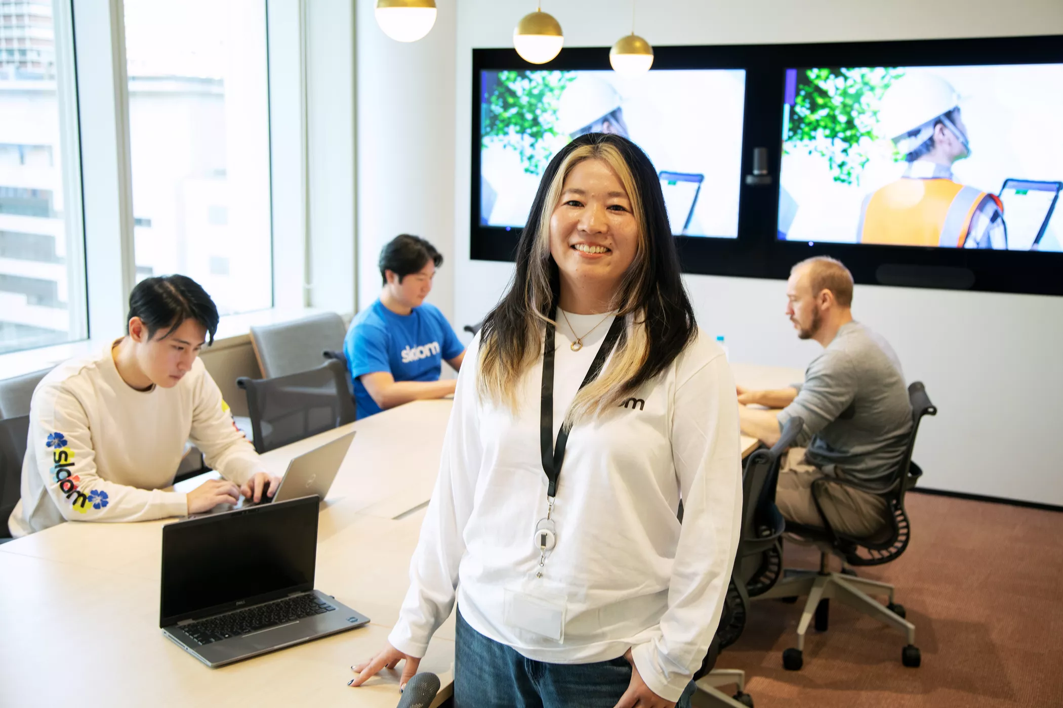 Chisato Takahashi in a meeting room with coworkers