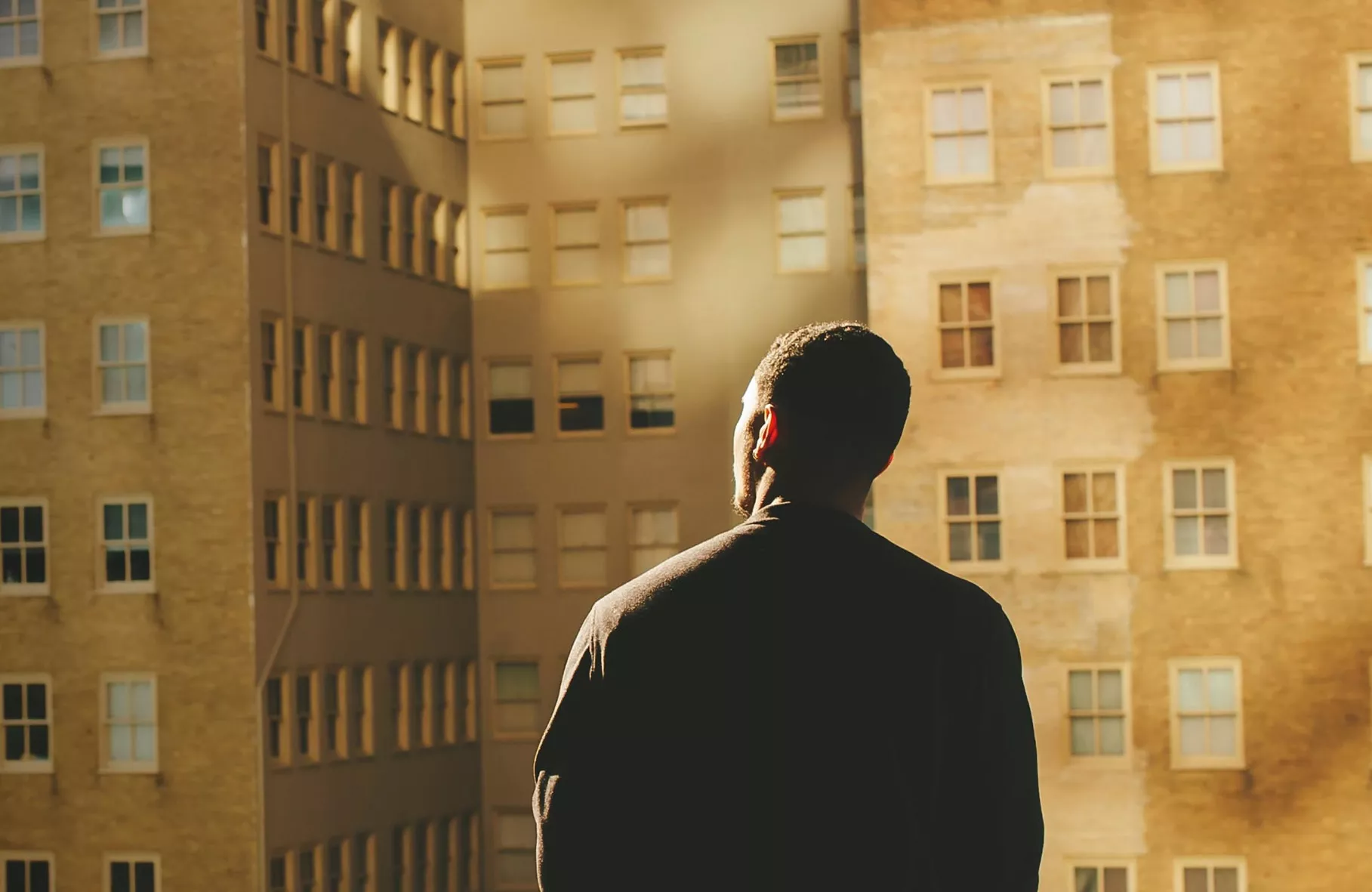 man looking at tall buildings