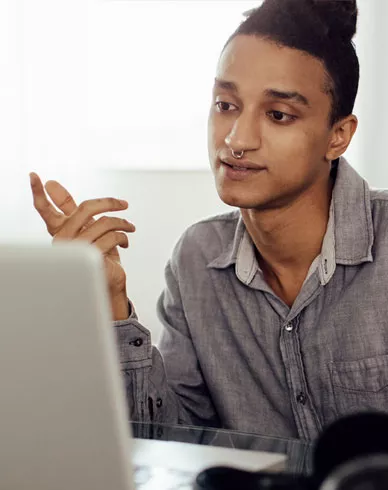 A person interacts with their laptop computer at home.