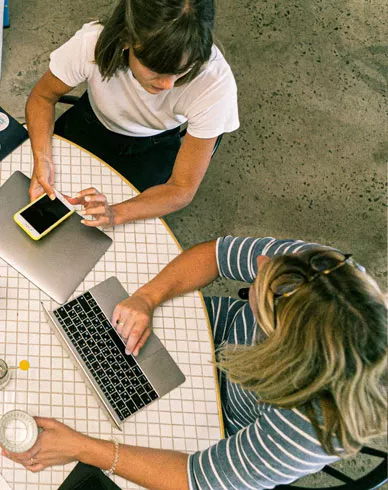 A group of employees working on laptops at a table.