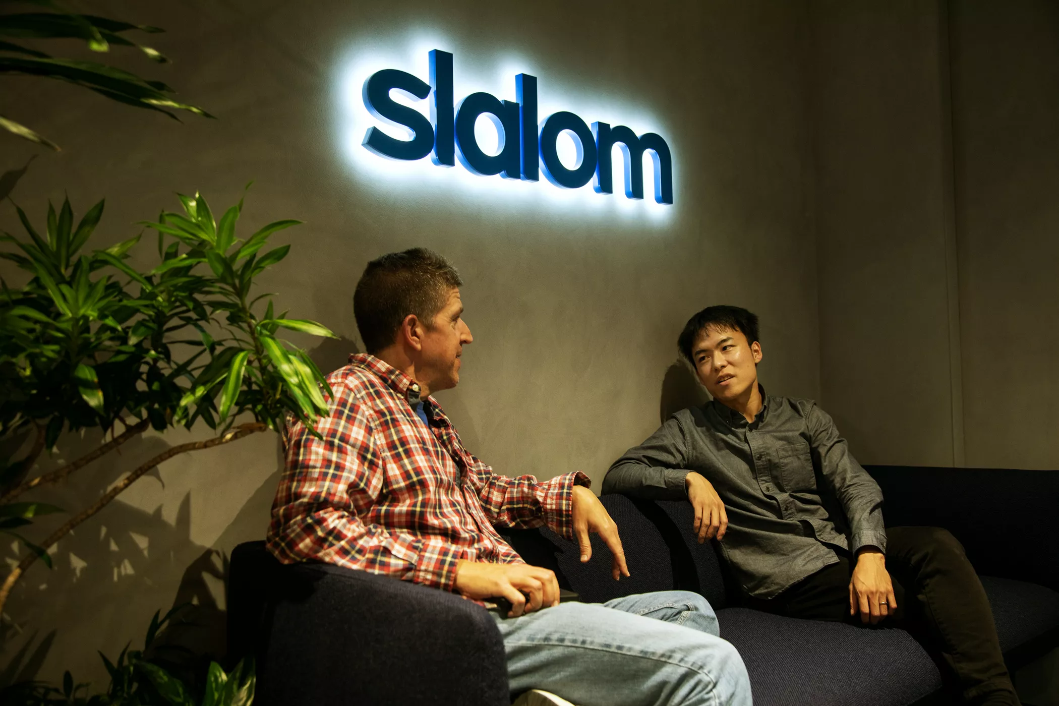 Kojiro Iizuka talking to a coworker on a sofa