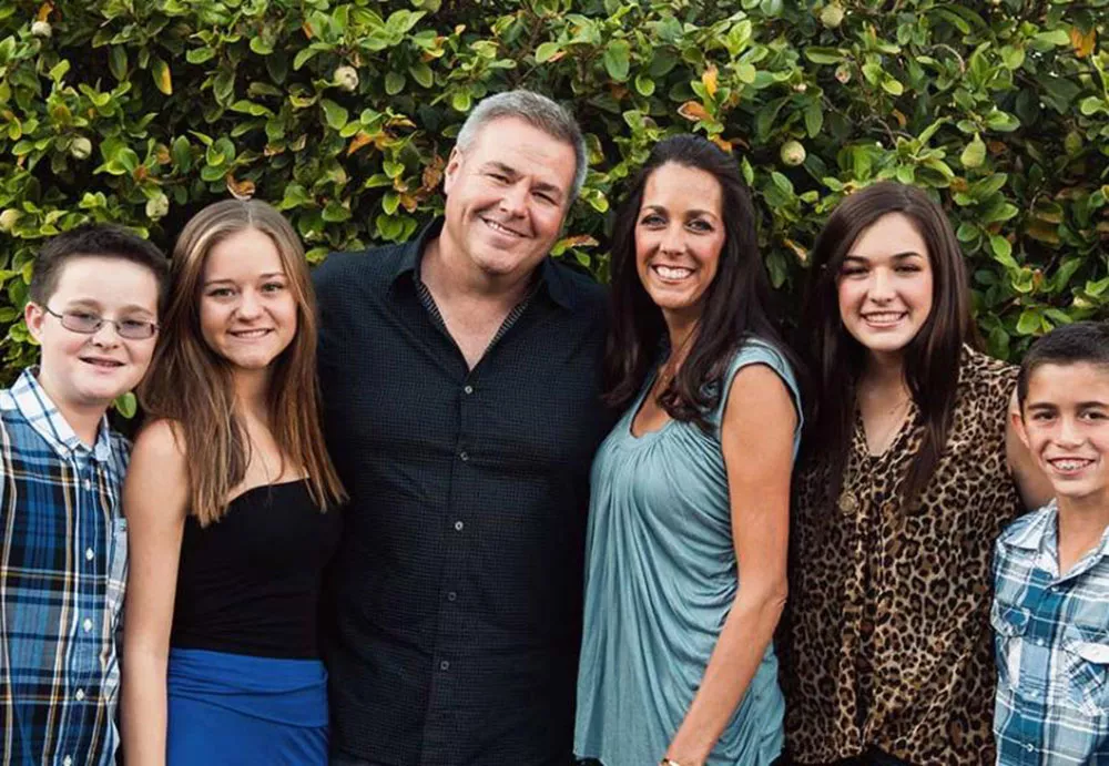 Slalom General Manager Jim Sikora and family in front of leafy backdrop.
