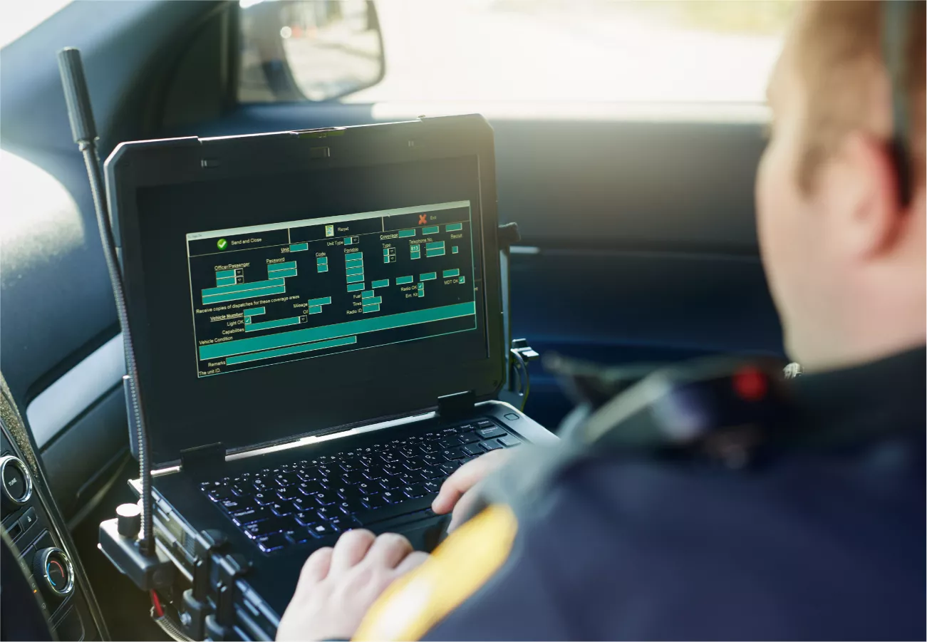 Police officer using laptop in vehicle