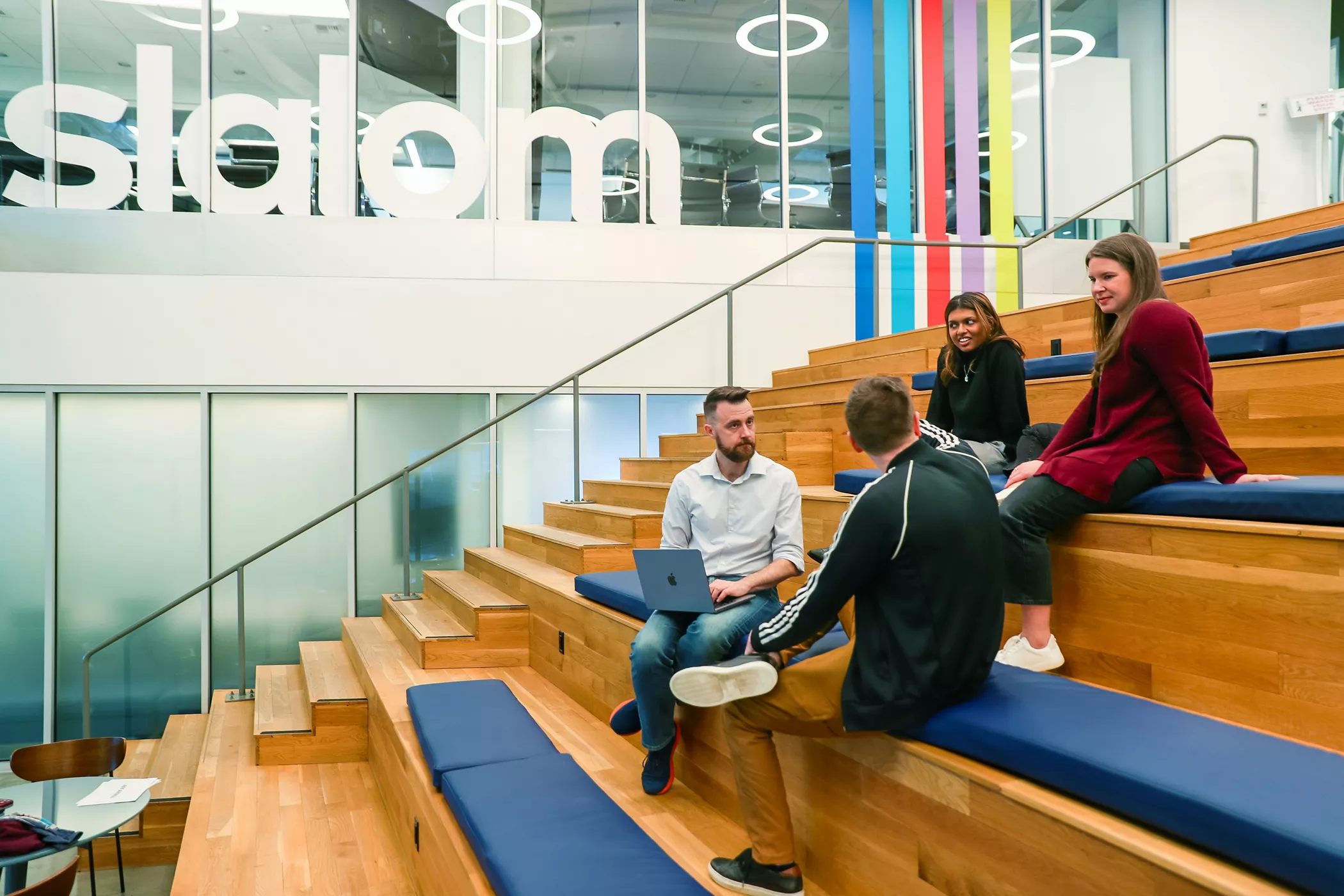 Slalom employees engage in a conversation inside the office.