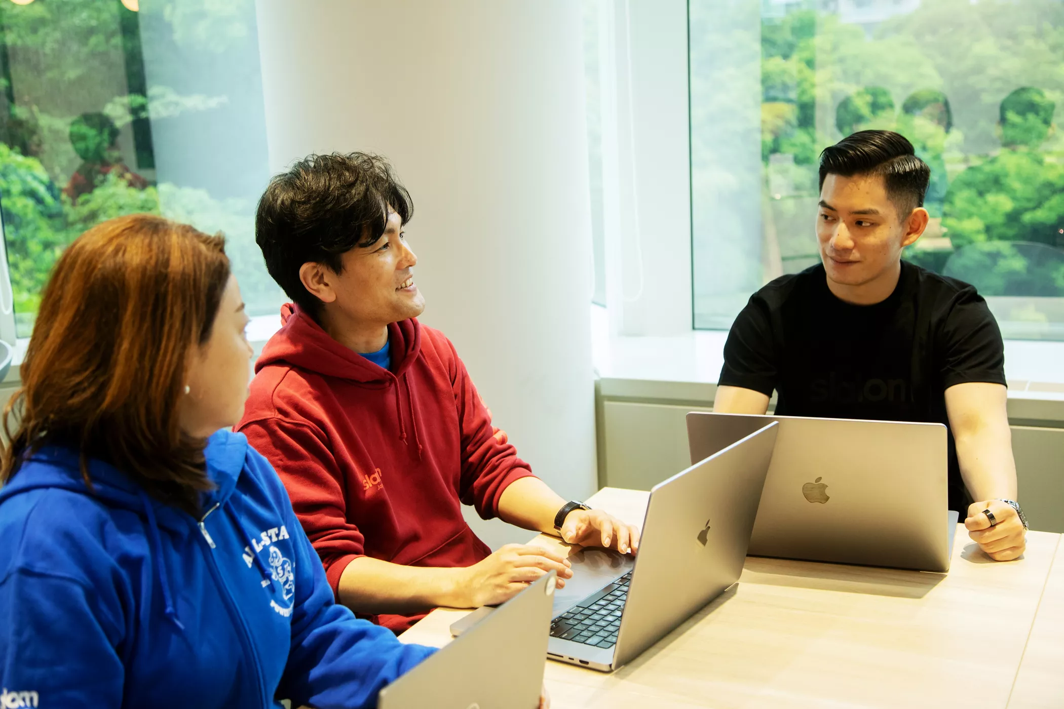 Tetsuya Nitta having a conversation with coworkers