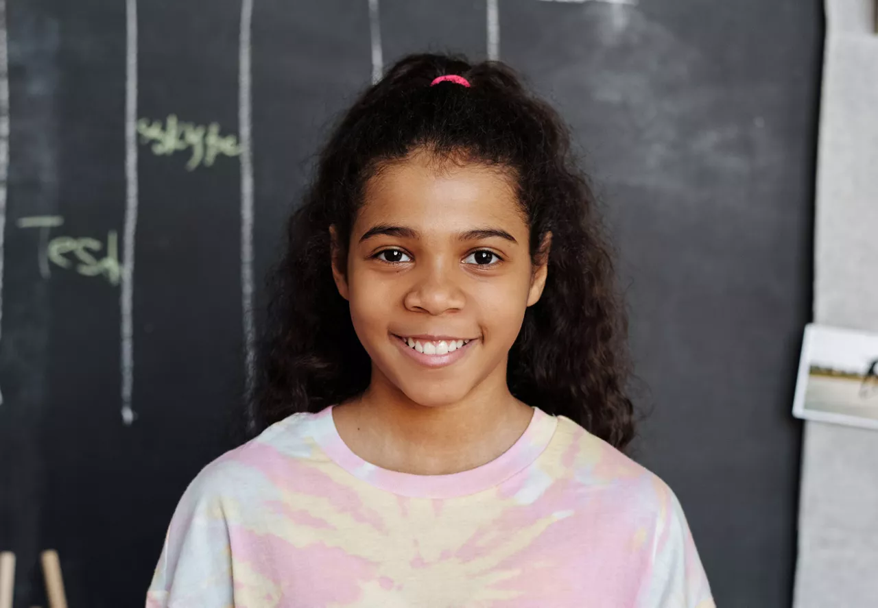 School photo of a young girl in a tie-dye shirt