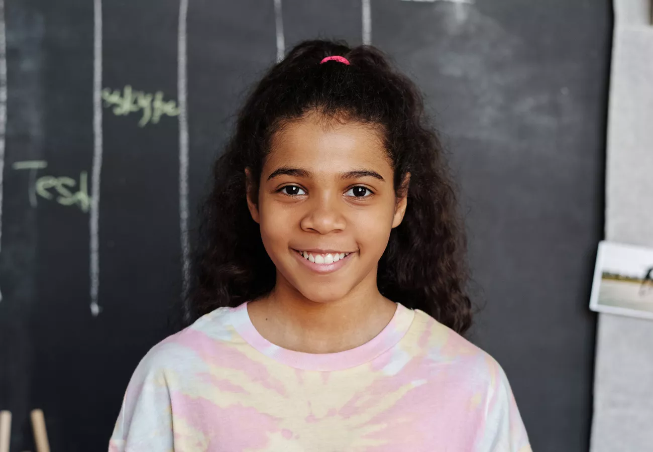 School photo of a young girl in a tie-dye shirt
