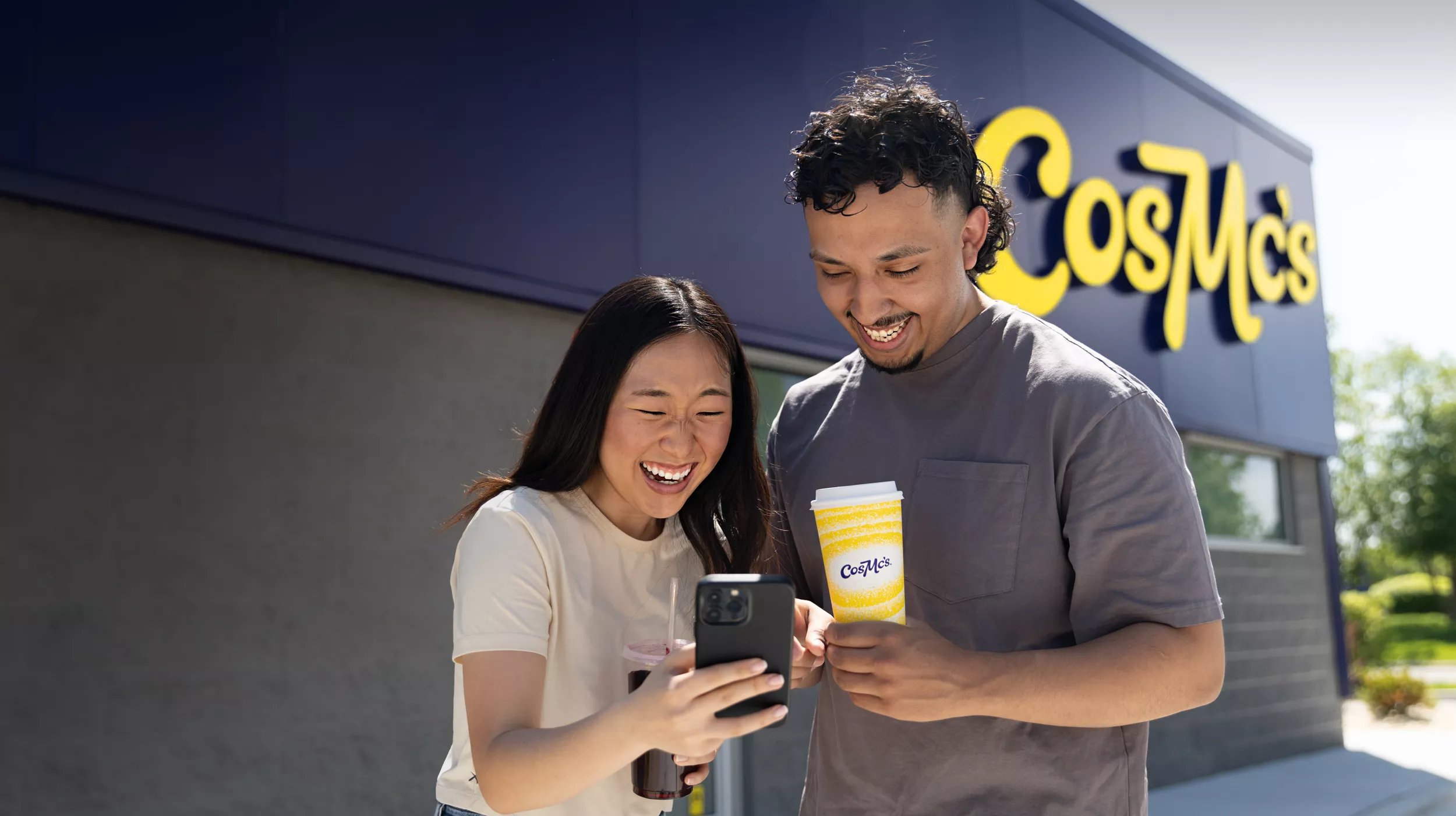 Two young adults use the CosMc's app on their mobile device.
