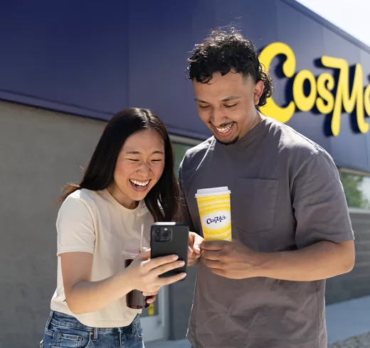 Two young adults use the CosMc's app on their mobile device.