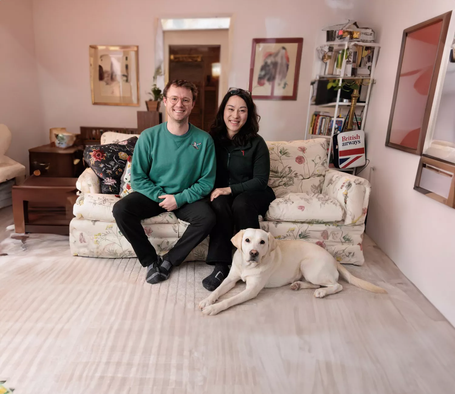 Pareja sentada en un sofá con un perro a sus pies