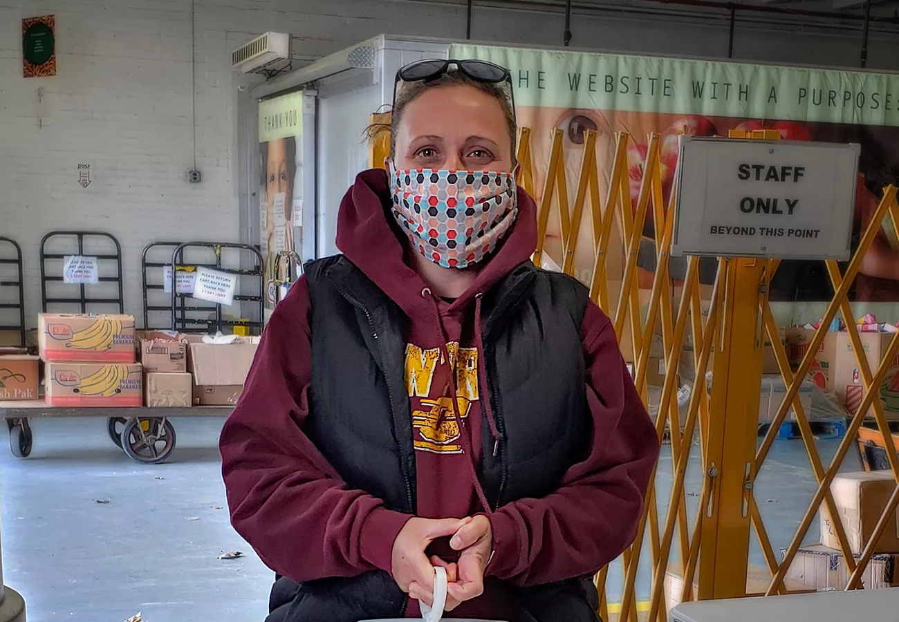 Masked woman volunteer at a warehouse.