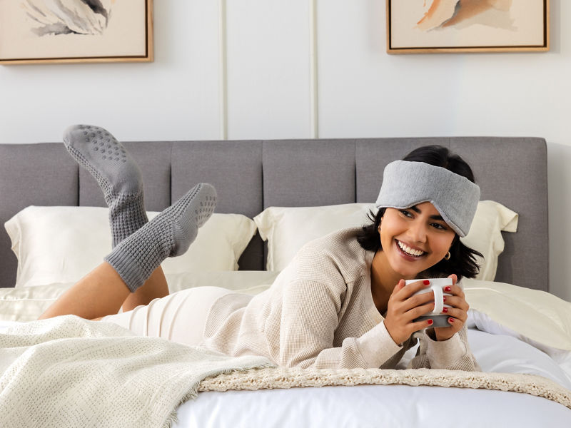 Lady lying on bed with coffee