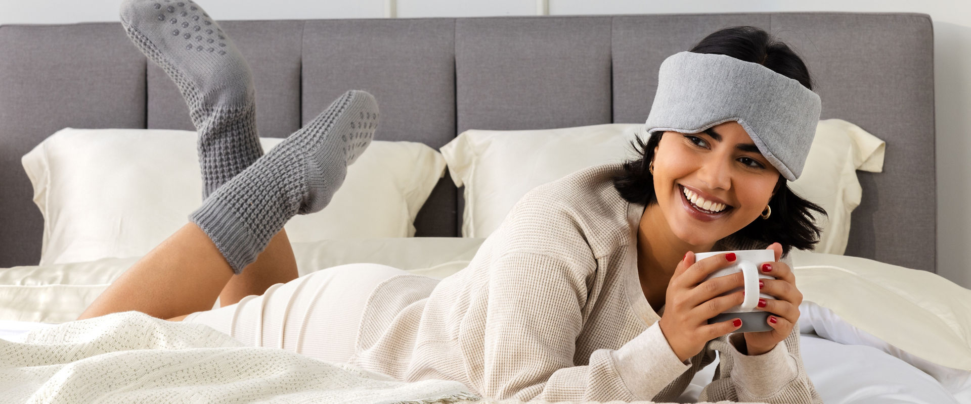 Lady lying on bed with coffee