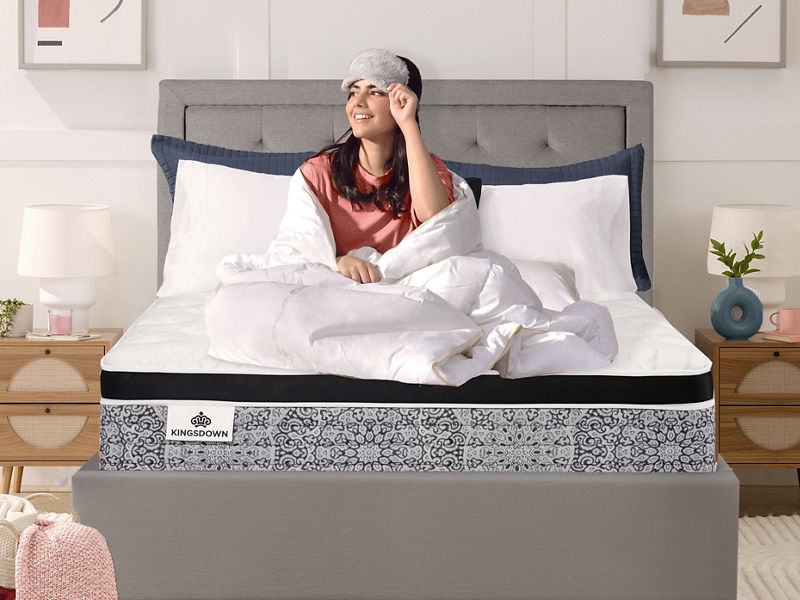 Medium-firm Serta Daystar mattress in a modern bedroom with blue pillows and black nightstands