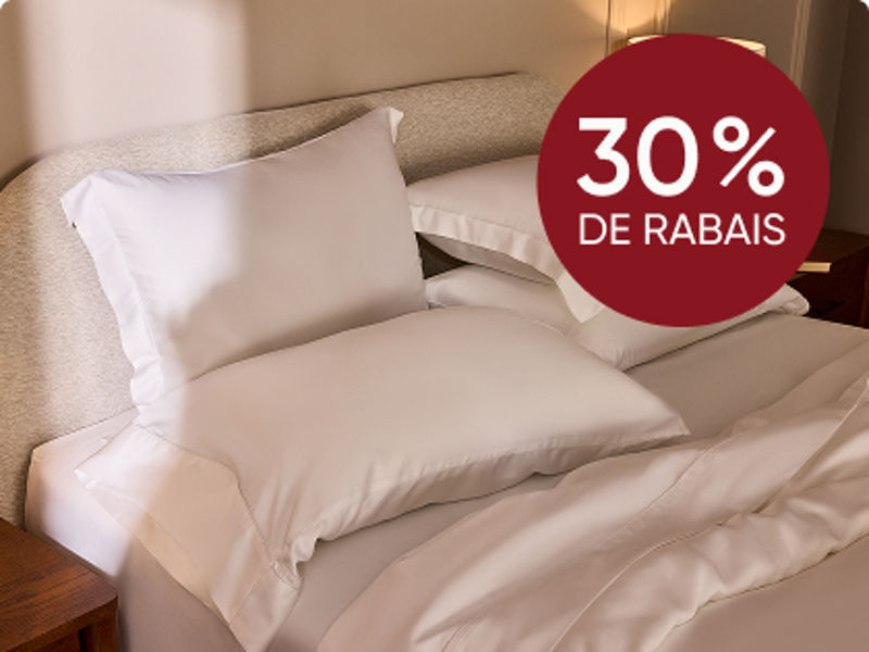 Chien sur des draps sur le lit