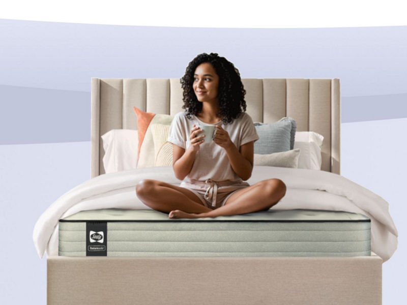 Medium-firm Serta Daystar mattress in a modern bedroom with blue pillows and black nightstands