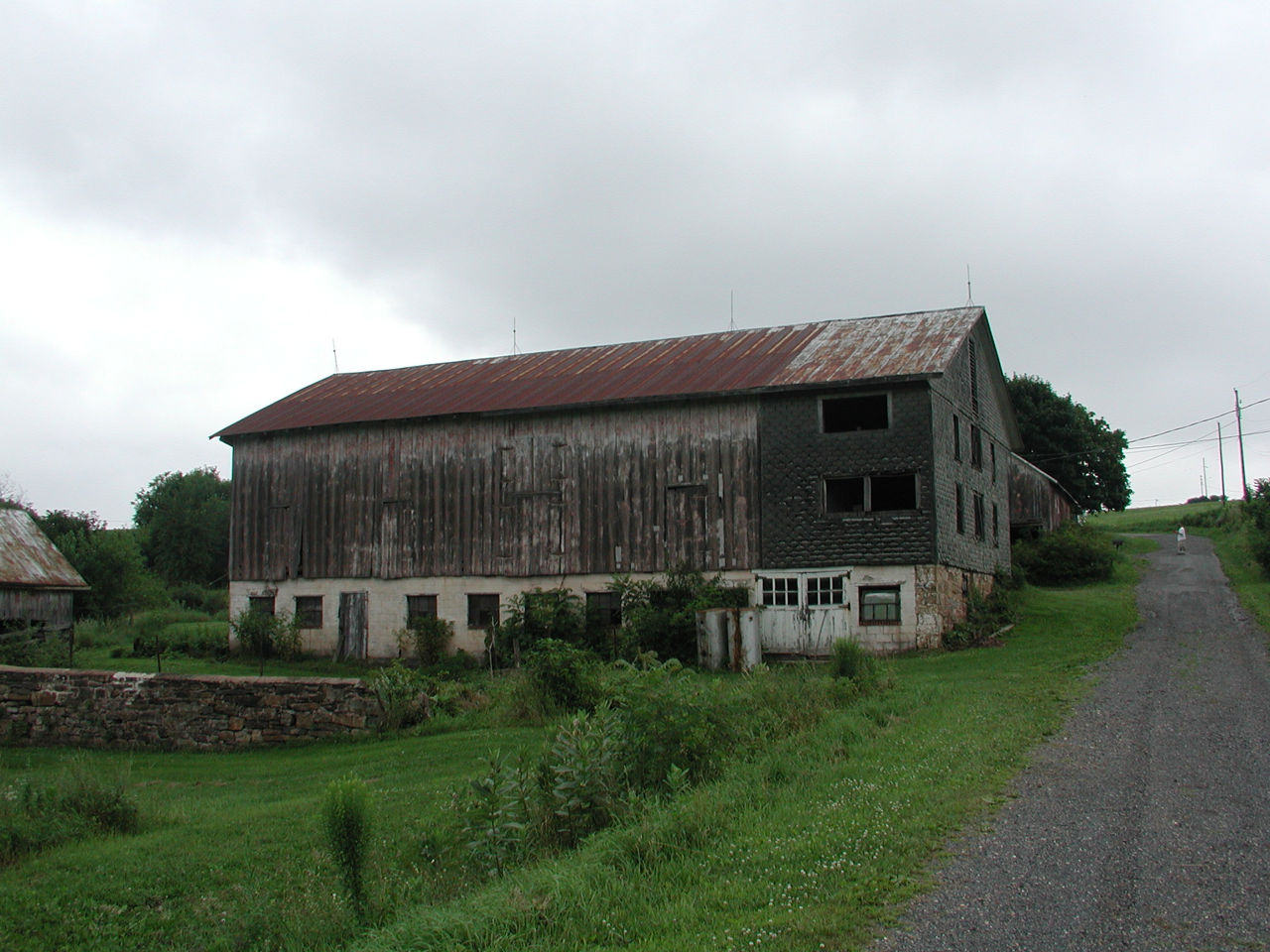 Large wood barn with concrete enclosed forebay with small windows.