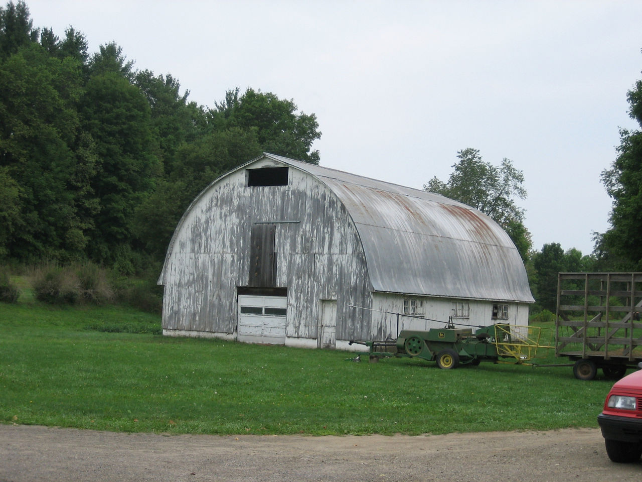 Two-story barn with rounded gambrel roof and doors in the gable end.