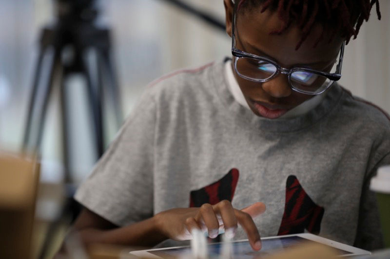 young boy using ipad with index finger