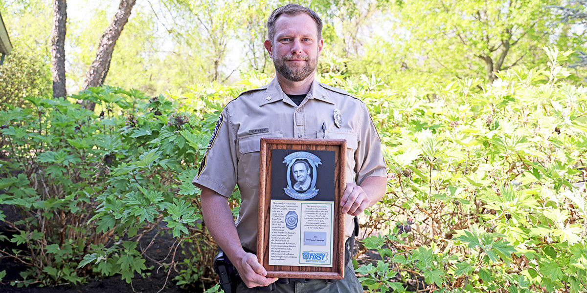 2023 Top Gerald L Greiner Environmental Protection Award Recipient, WCO Justin Boatwright, holding the award plaque.