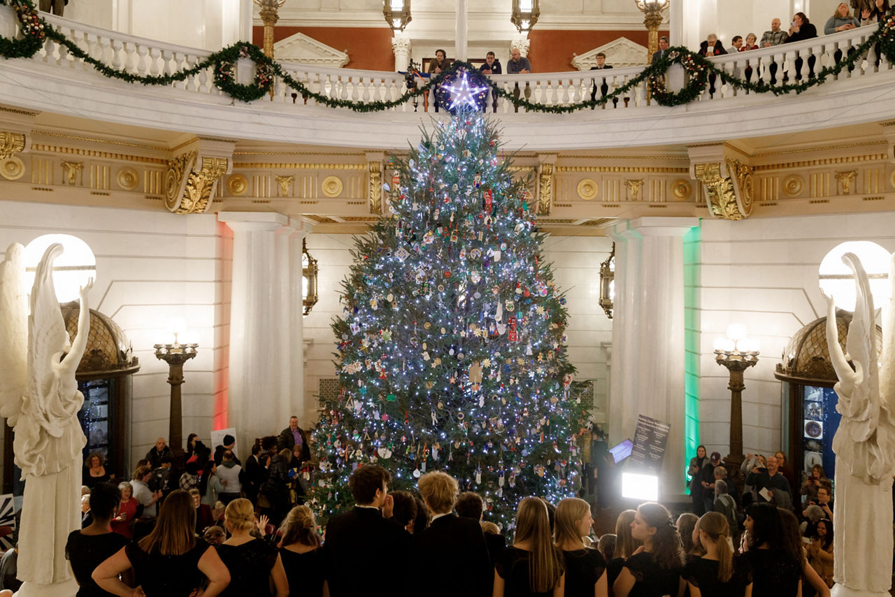 people standing around state capitol christmas tree